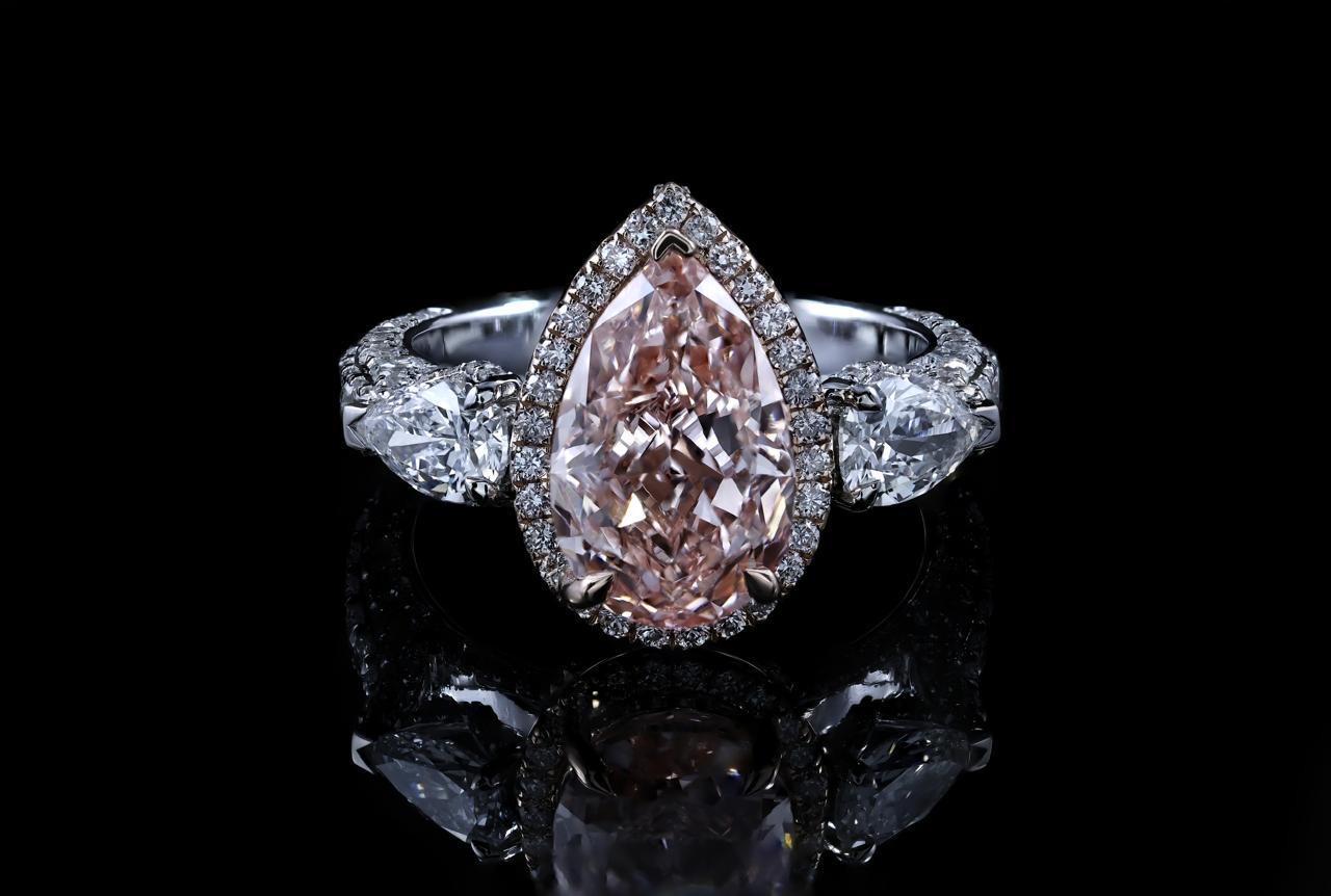 Fancy pink pear-shaped diamond ring with diamond halo, custom designed by Diggs & Company